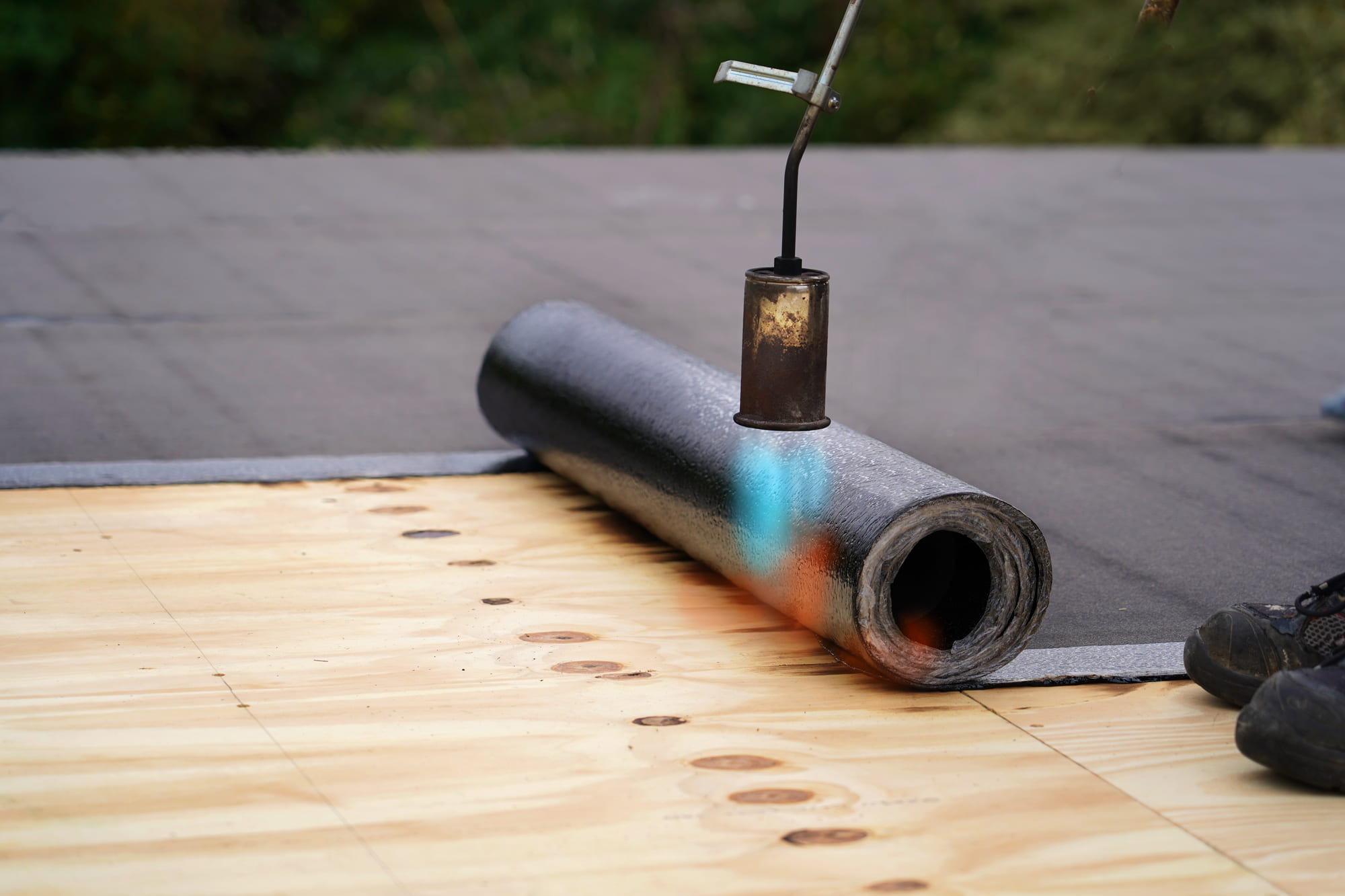 Crew member installing a flat roof on a home in Blue Bell, PA.